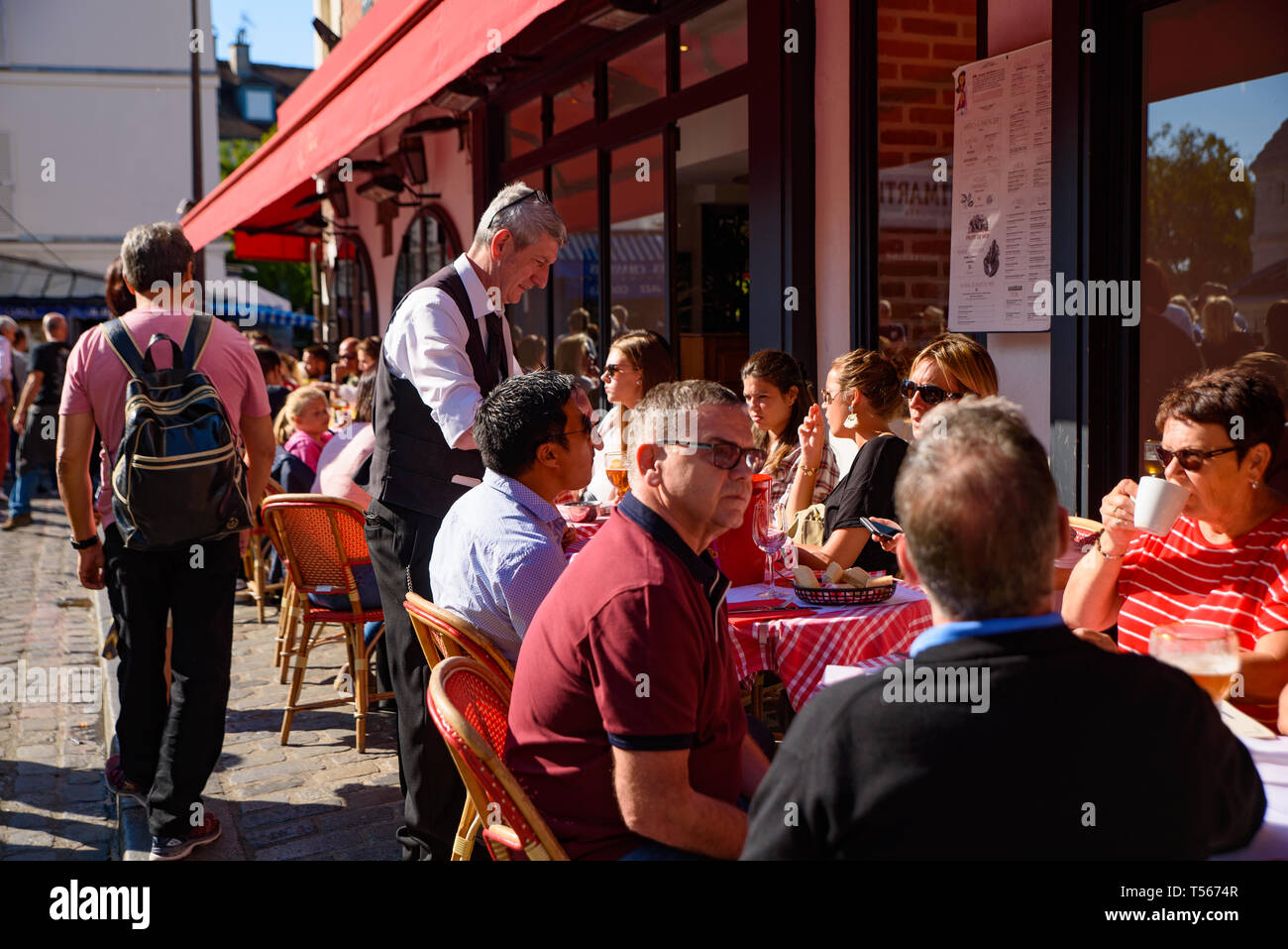 Persone mangiare presso i posti a sedere esterni a Montmartre, Francia Foto Stock