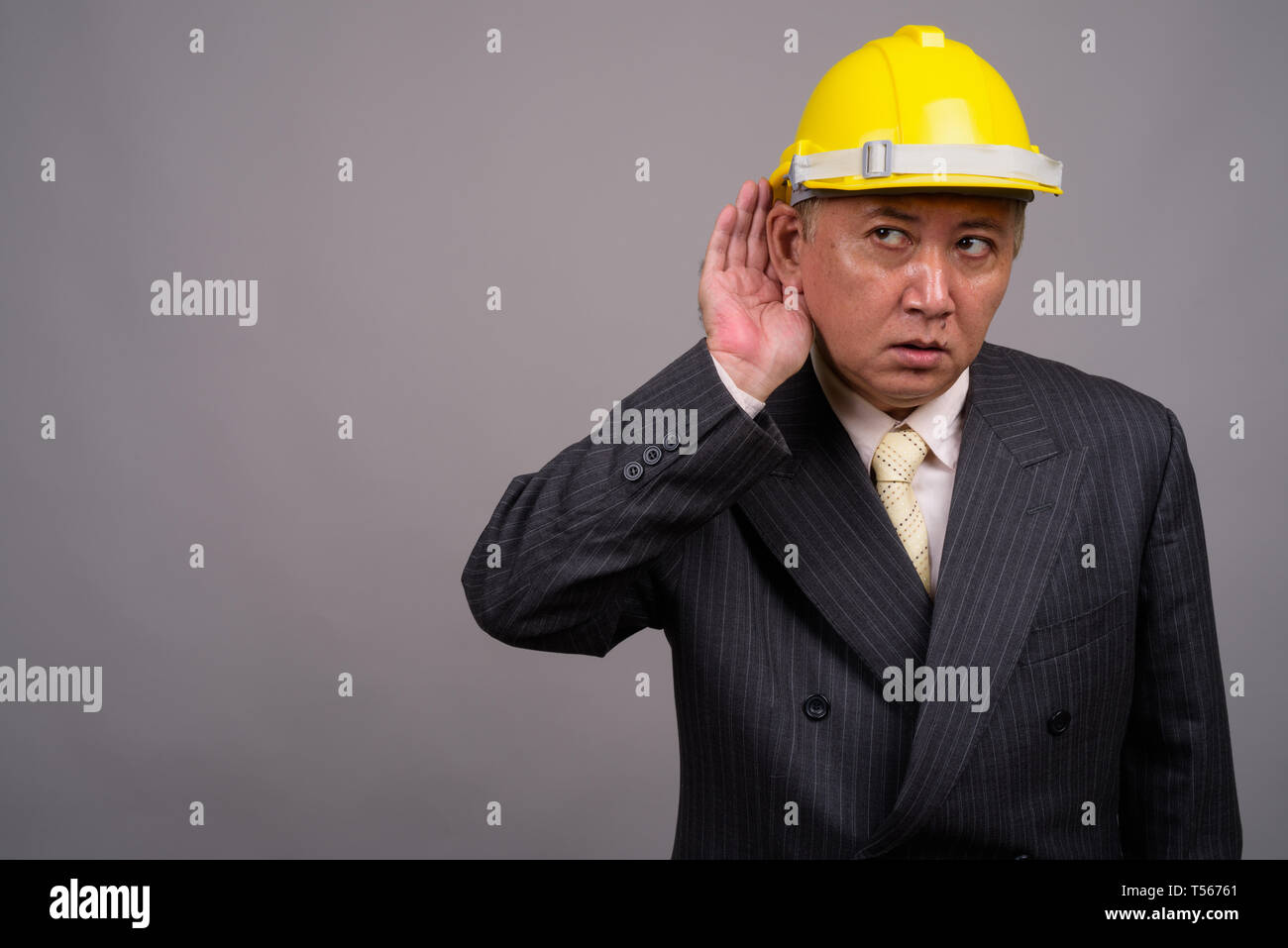 Coppia asiatica imprenditore di costruzione contro uno sfondo grigio Foto Stock