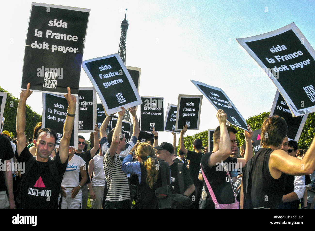 PARIGI - grande folla di persone, attivisti per l'AIDS, Act Up Paris, ONG, dimostrazione sul prato Champs-de-Mars, parco vicino alla Torre Eiffel, protesta per maggiori finanziamenti per il Fondo Mondiale, protesta attivista, tiene manifesti di protesta ACT UP, attivismo giovanile, slogan Foto Stock