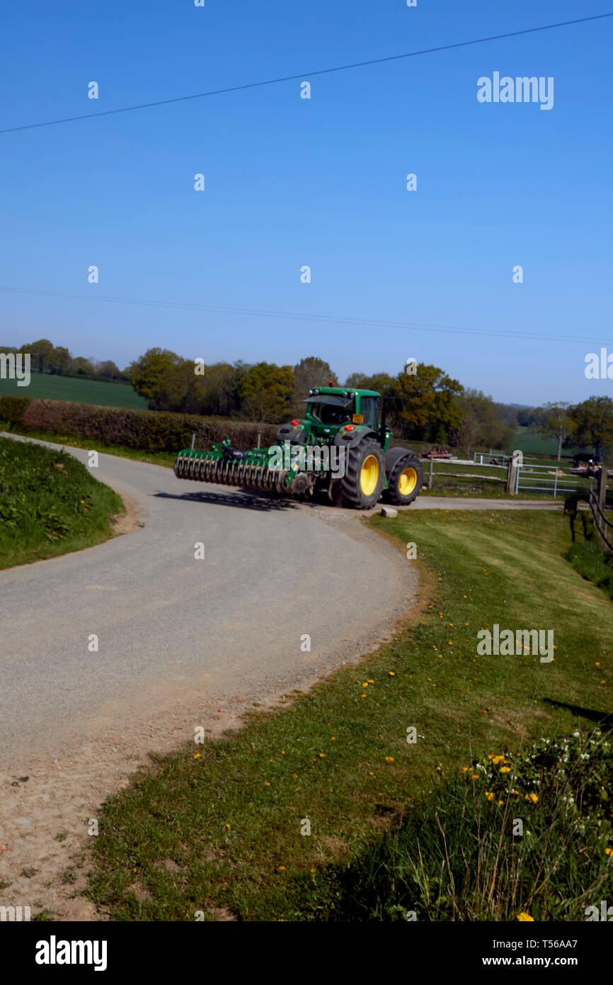 Macchine agricole su una strada con curve nel Kent con un blu cielo sereno sfondo, Kent, England, Regno Unito, Europa Foto Stock