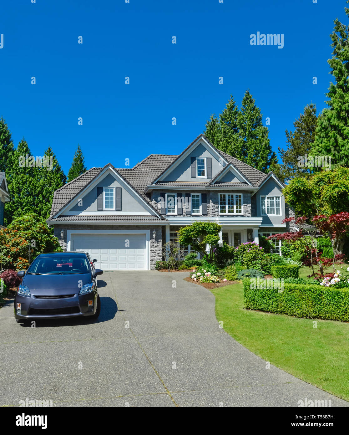 Di lusso casa suburbana con doppio garage e auto parcheggiate sul viale di calcestruzzo Foto Stock