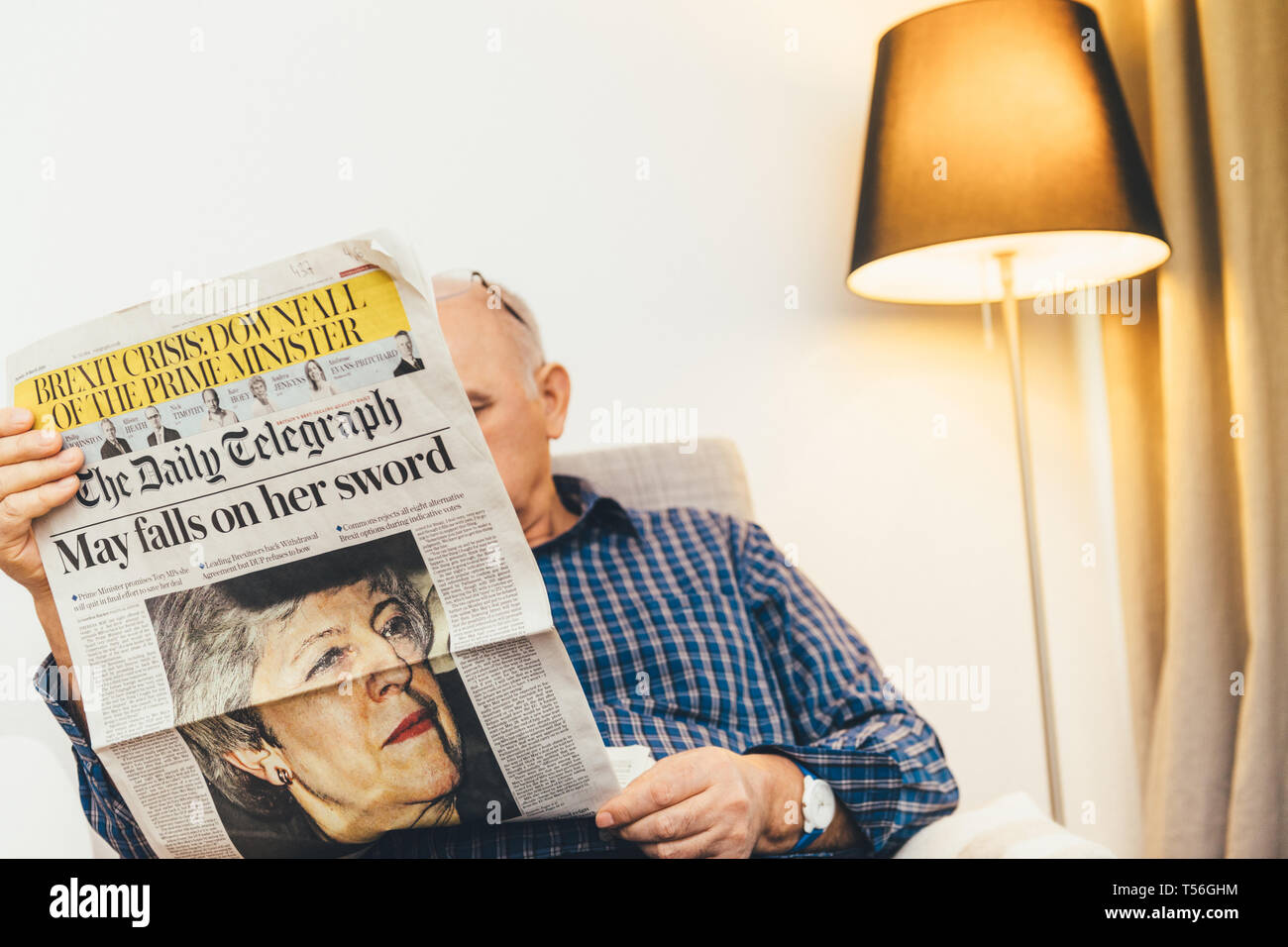 Parigi, Francia - 29 Mar 2019: curioso uomo senior di lettura nel salotto più recenti il britannico Daily Telegraph newspaper UK premere dotate di Theresa Maggio PM sul coperchio anteriore può cade sul suo spade Foto Stock