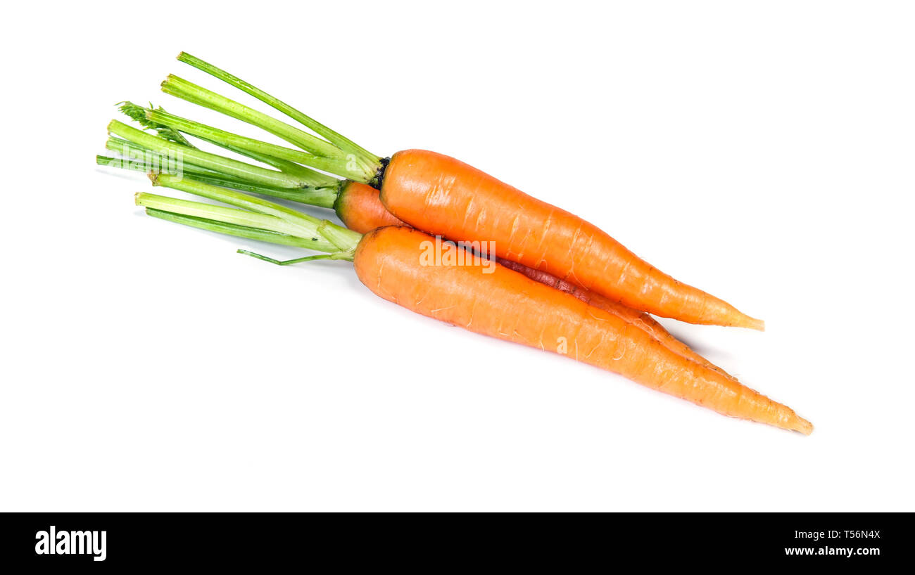Appena presentate spennate carotine isolato su bianco. Cumulo di colore arancione carota fresca verdura con steli verdi. Foto Stock