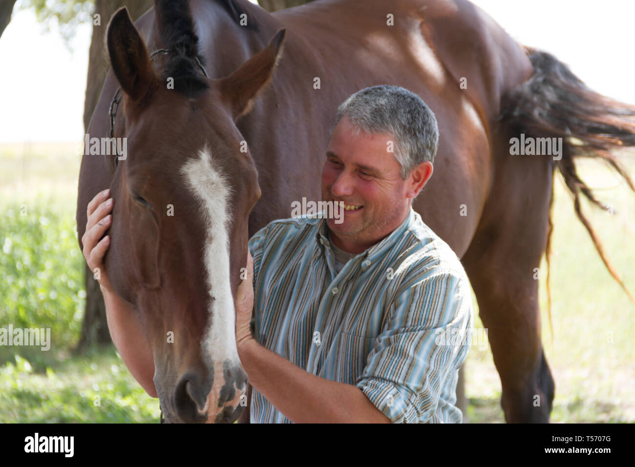 Uomo sorridente con il suo cavallo in Argentina campagna Foto Stock
