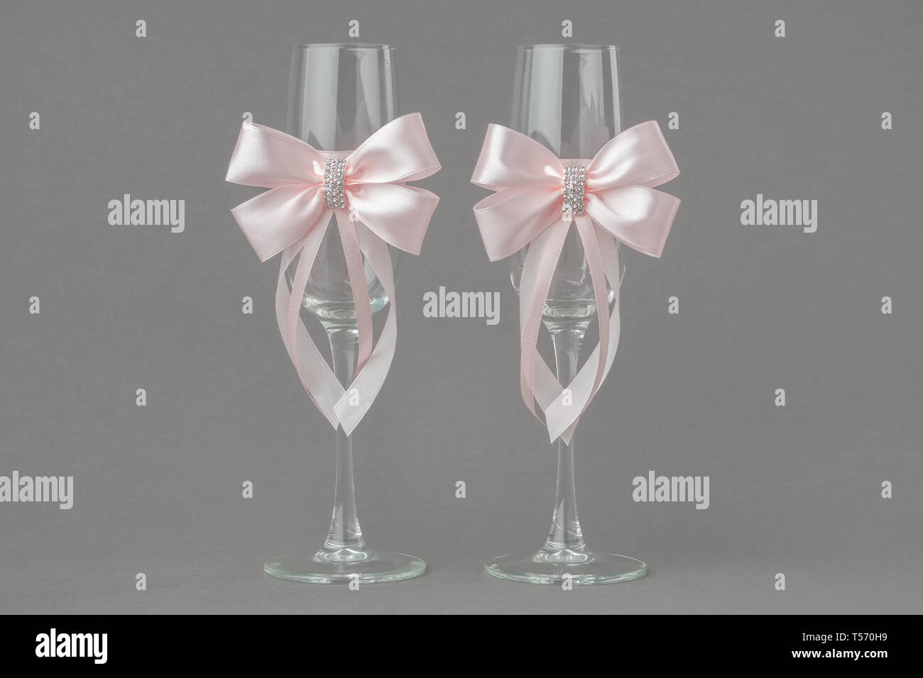 Matrimonio di due bicchieri di vino decorate con nastri di colore rosa. Foto Stock