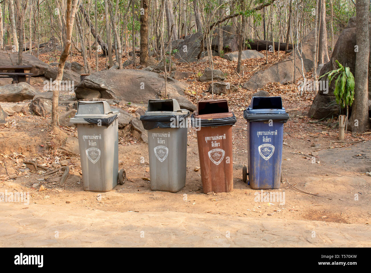 Nei pressi di Chaiyaphum, Tailandia - 17 Marzo 2019: i colori dei cestini in un luogo pubblico vicino ai boschi con iscrizioni in thai Foto Stock