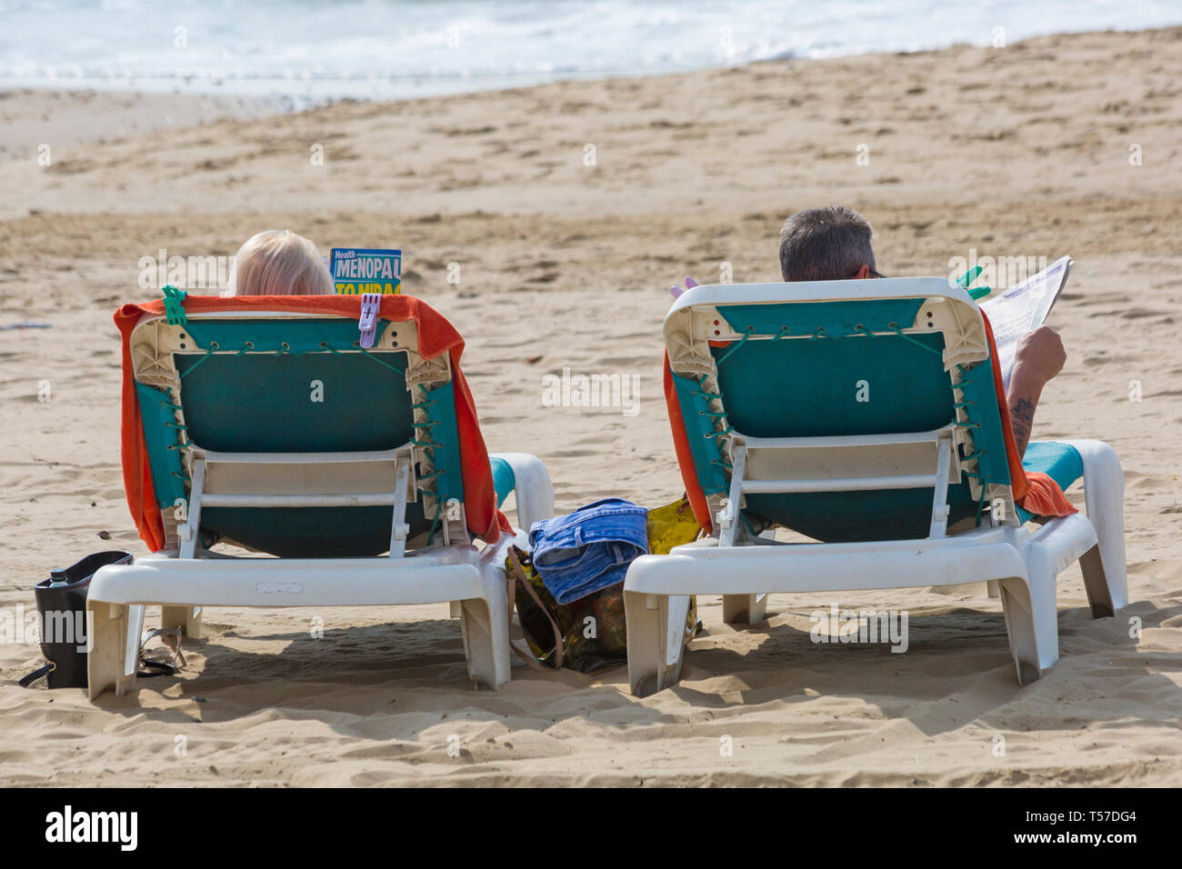 Bournemouth Dorset, Regno Unito. 22 apr, 2019. Regno Unito meteo: dopo un inizio nebuloso il glorioso meteo continua con caldo e soleggiato, come testa beachgoers al mare per godere del calore e del sole a Bournemouth spiagge del Lunedì di Pasqua prima che i cambiamenti climatici e il ritorno al lavoro. Matura a prendere il sole sulle sedie a sdraio di lettura. Credito: Carolyn Jenkins/Alamy Live News Foto Stock