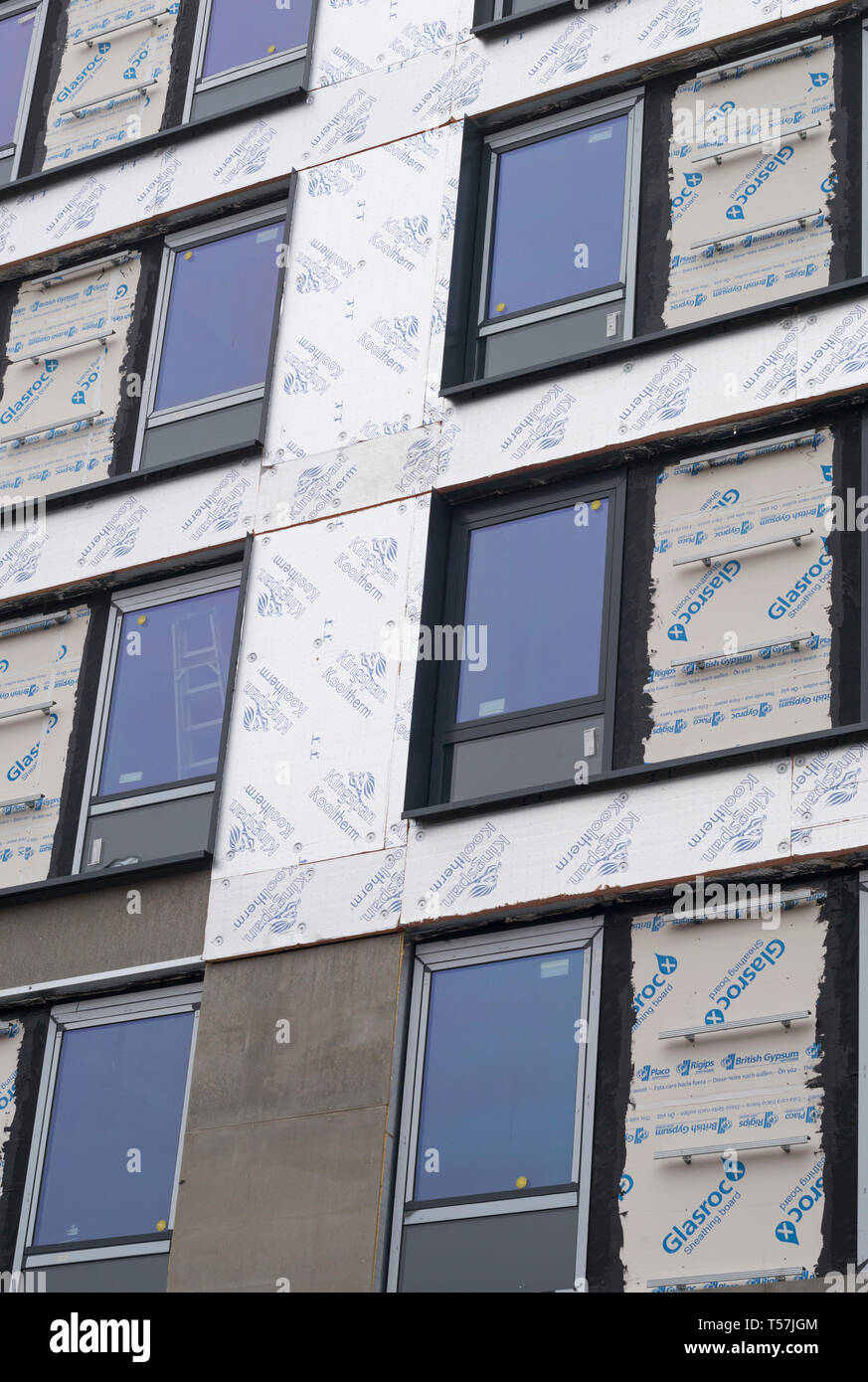 Pannelli isolanti e finestre con doppi vetri sulla parete esterna del blocco di appartamenti in costruzione Foto Stock