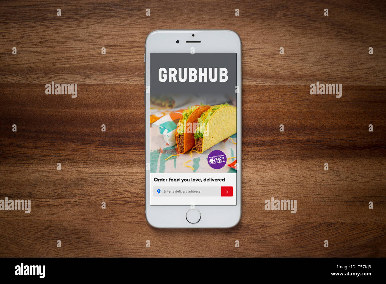 Un iPhone che mostra il sito web Grubhub poggia su una semplice tavola di legno (solo uso editoriale). Foto Stock