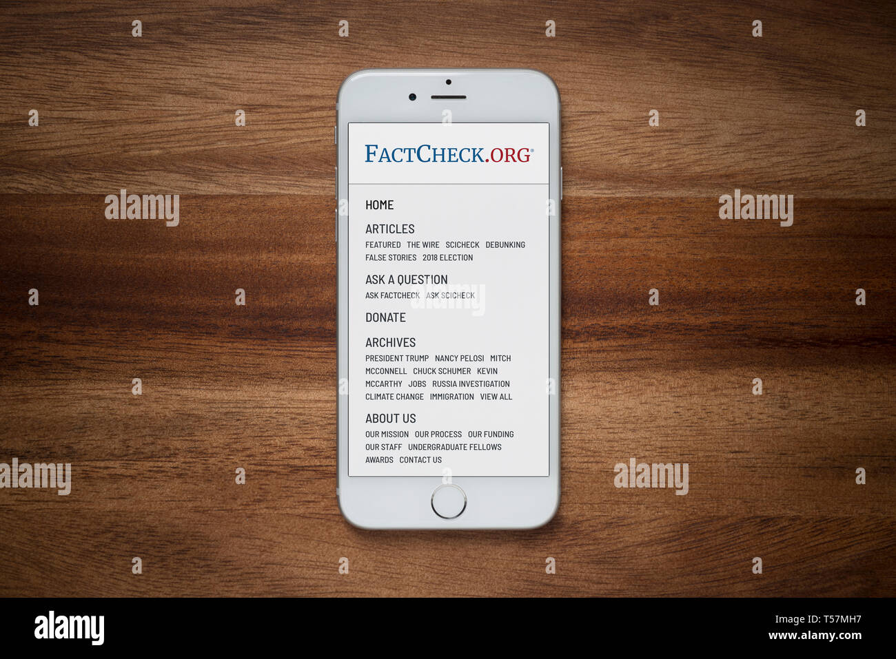 Un iPhone che mostra il sito FactCheck.org poggia su una semplice tavola di legno (solo uso editoriale). Foto Stock