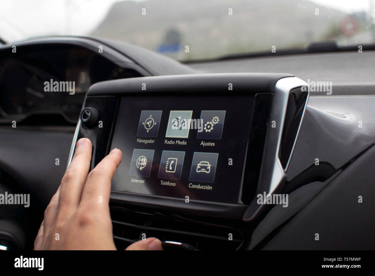 Maschio lato toccando lo schermo in un auto moderna. Un uomo alla guida di un'auto. Auto vista interna del display digitale del cruscotto tracker GPS Navigator di monitor in Spagna, 2019. Foto Stock