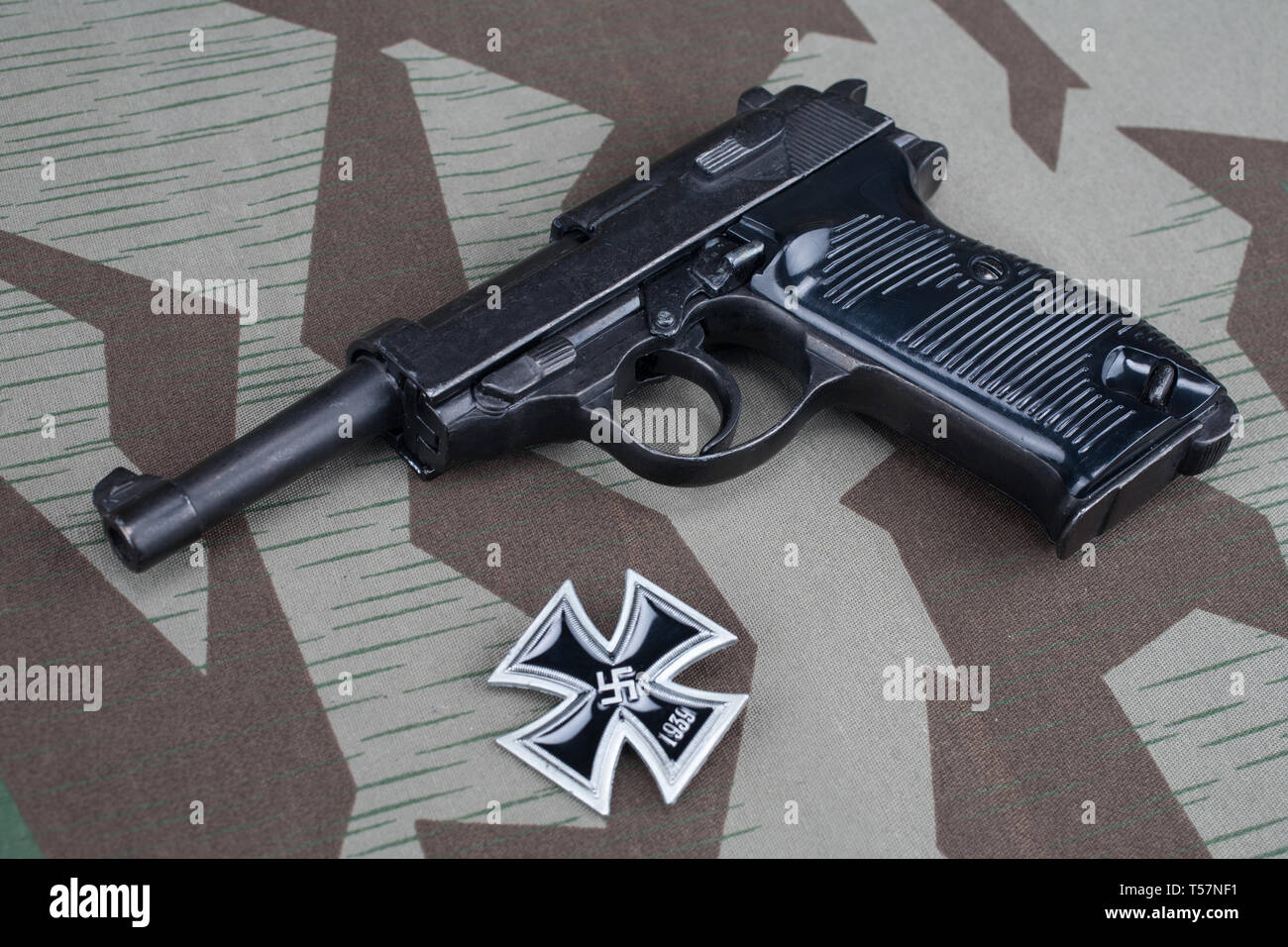 Durante la Seconda guerra mondiale era nazista esercito tedesco 9 mm pistola semi-automatica con croce in ferro sul premio mimetizzata sfondo uniforme Foto Stock