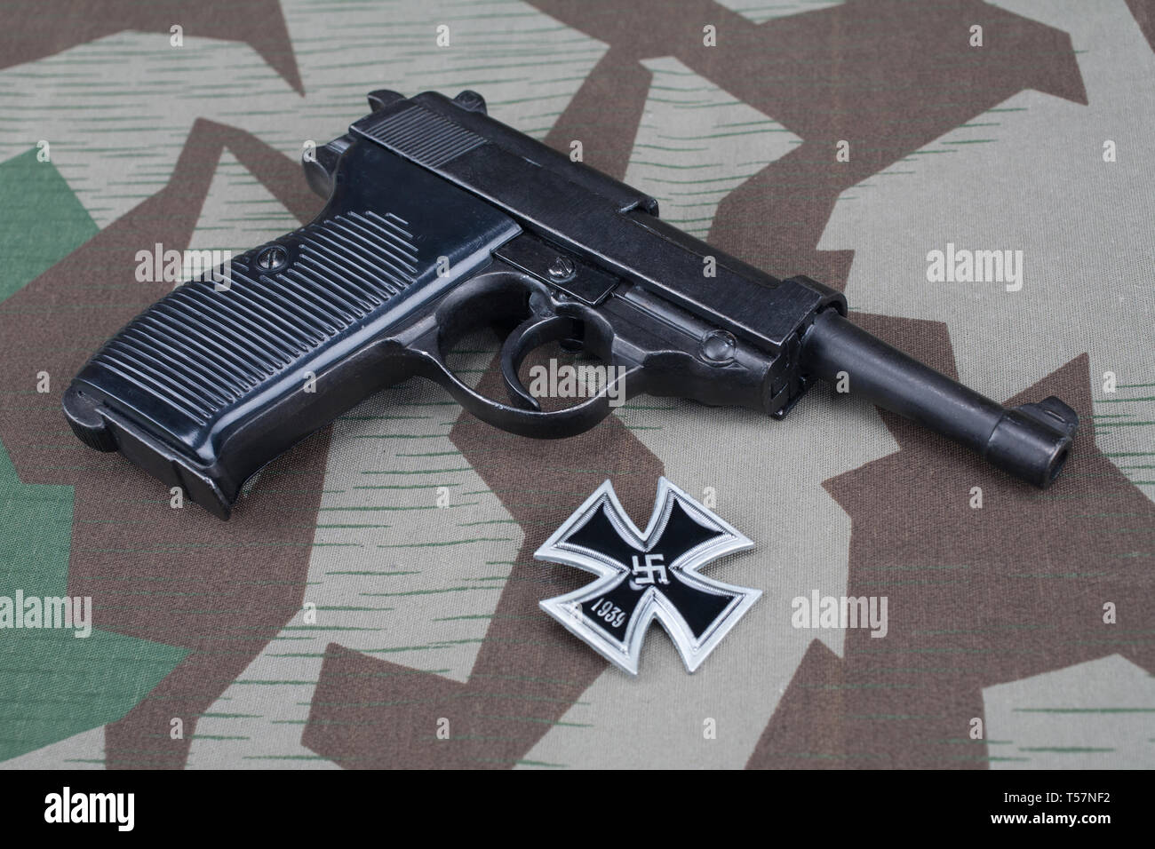 Durante la Seconda guerra mondiale era nazista esercito tedesco 9 mm pistola semi-automatica con croce in ferro sul premio mimetizzata sfondo uniforme Foto Stock
