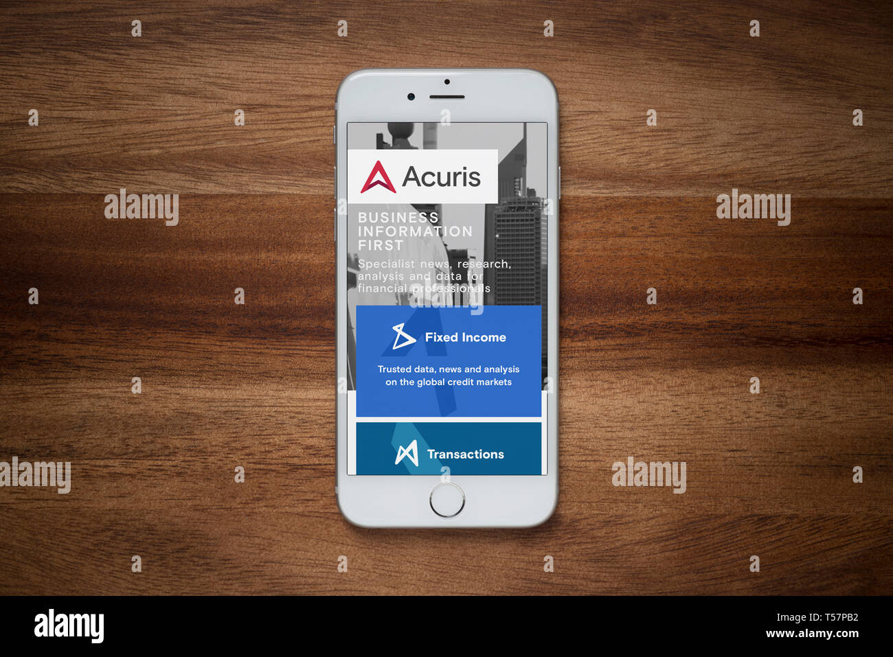 Un iPhone che mostra il sito web Acuris poggia su una semplice tavola di legno (solo uso editoriale). Foto Stock