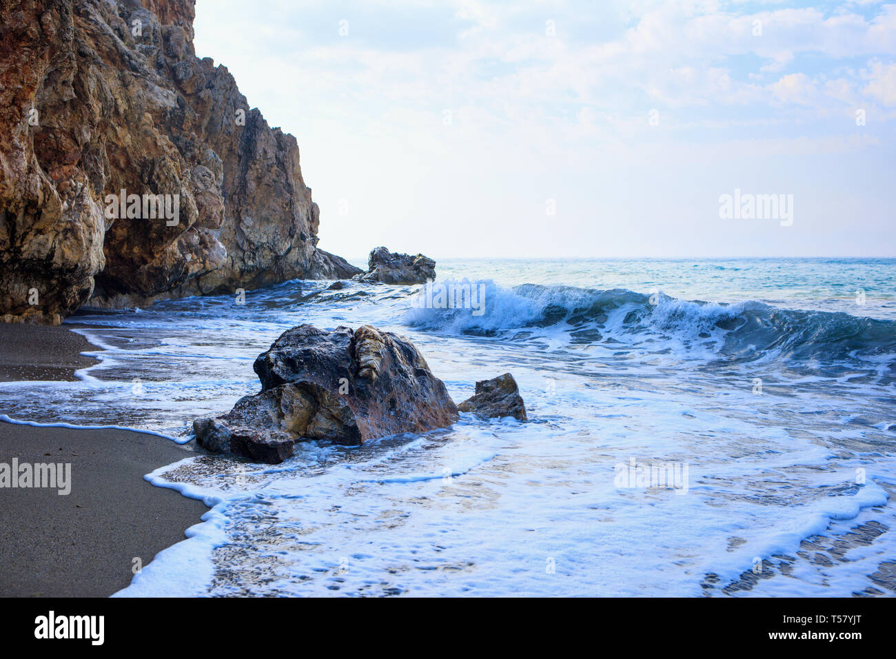 Una bellissima spiaggia di sabbia e morbido blu oceano onda con schiuma bianca nei pressi di cave. Foto Stock