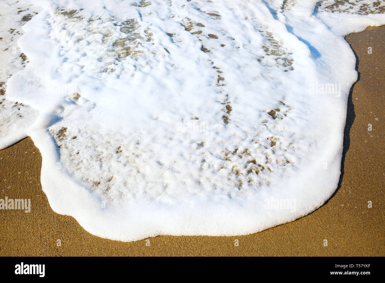 Vista dall'alto sulla bella spiaggia di sabbia e il blu oceano onda con schiuma bianca. Foto Stock