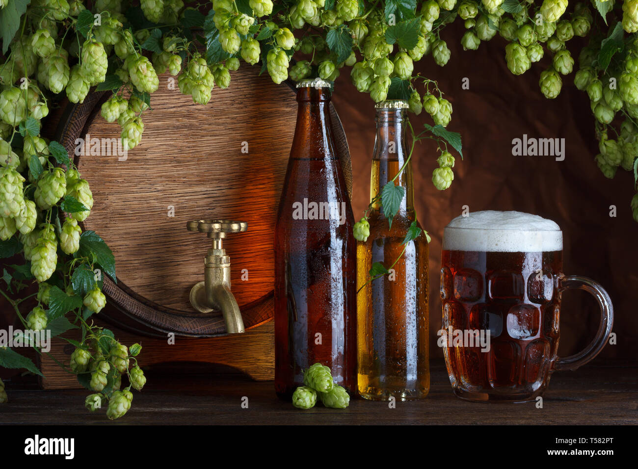 Le bottiglie di birra con un bicchiere di birra e canna con luppolo fresco cornice still-life Foto Stock