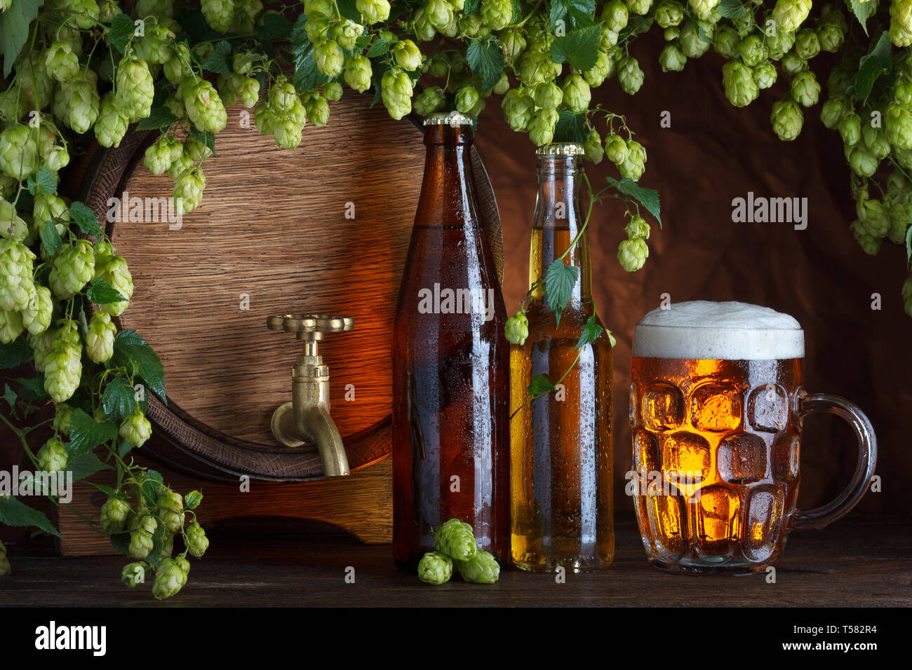 Le bottiglie di birra con un bicchiere di birra e canna con luppolo fresco cornice still-life Foto Stock