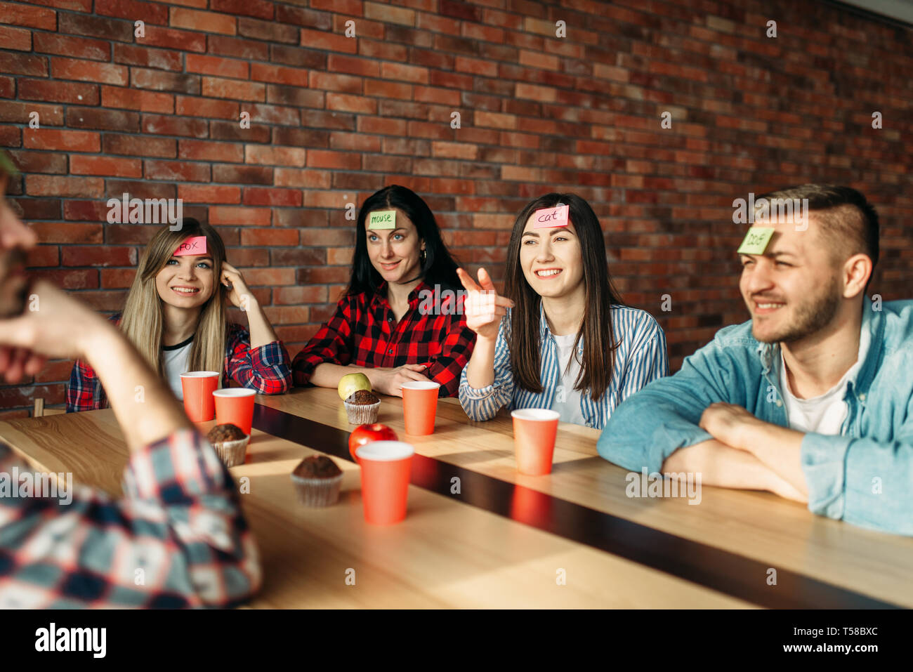 Sorridente amici giocando sticker note a fronte Foto Stock