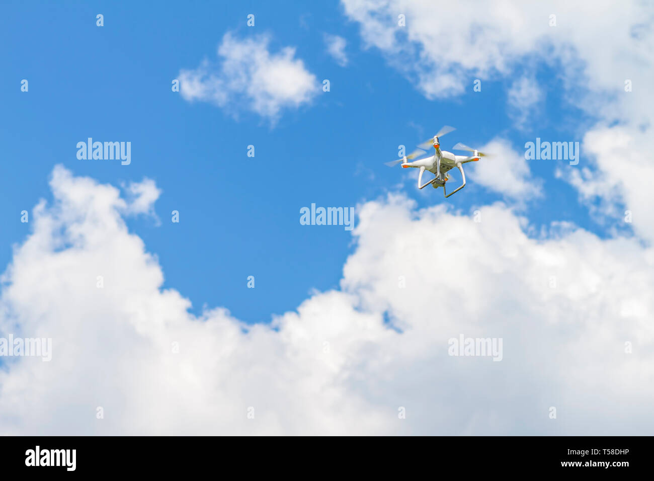 White drone quad copter con alta risoluzione Telecamera digitale volare nel cielo blu Foto Stock