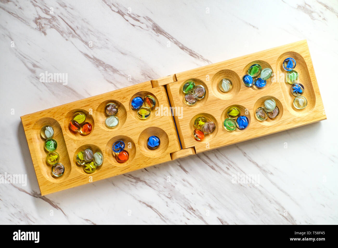 Mancala tradizionale tavolo con pezzi di vetro sulla tavola di marmo Foto Stock