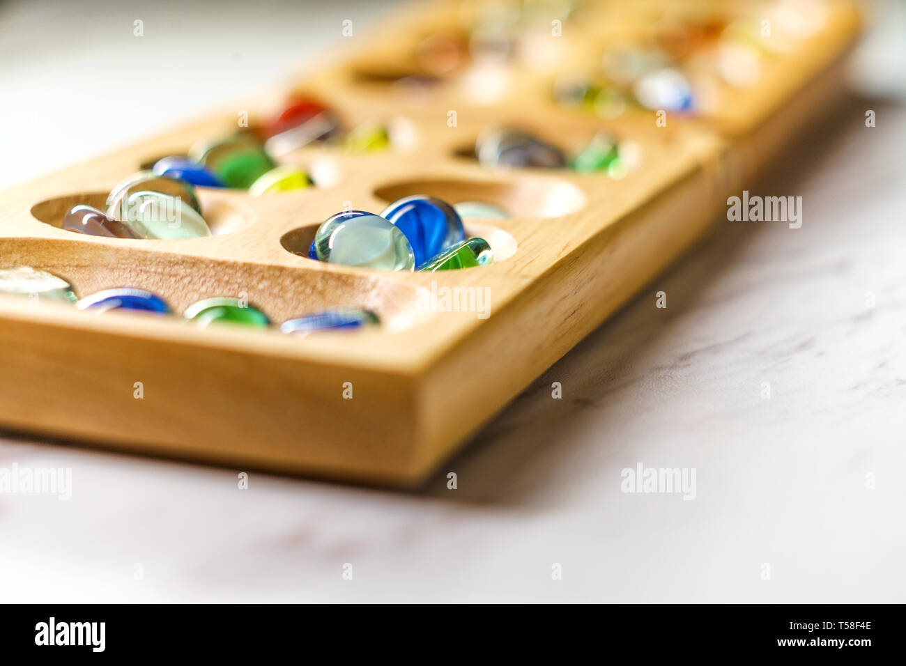 Mancala tradizionale tavolo con pezzi di vetro sulla tavola di marmo Foto Stock