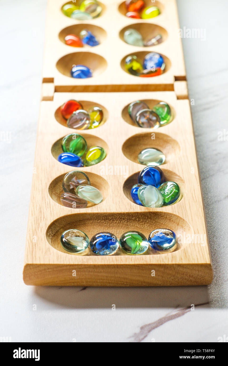 Mancala tradizionale tavolo con pezzi di vetro sulla tavola di marmo Foto Stock