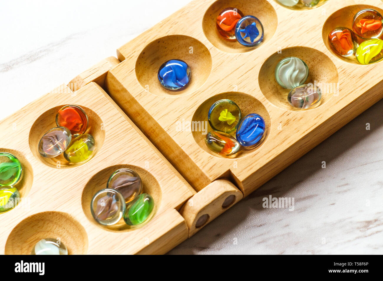 Mancala tradizionale tavolo con pezzi di vetro sulla tavola di marmo Foto Stock