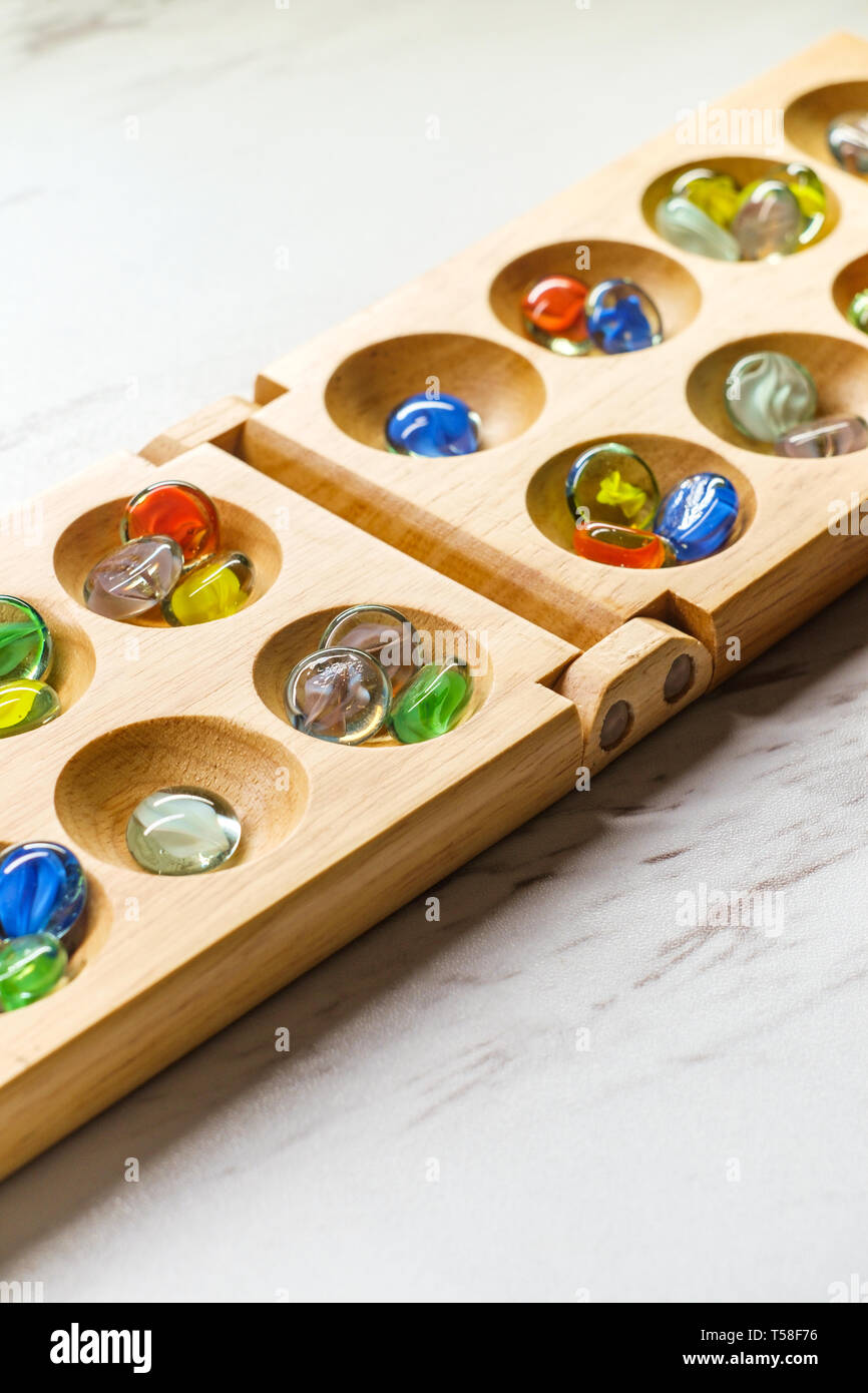 Mancala tradizionale tavolo con pezzi di vetro sulla tavola di marmo Foto Stock