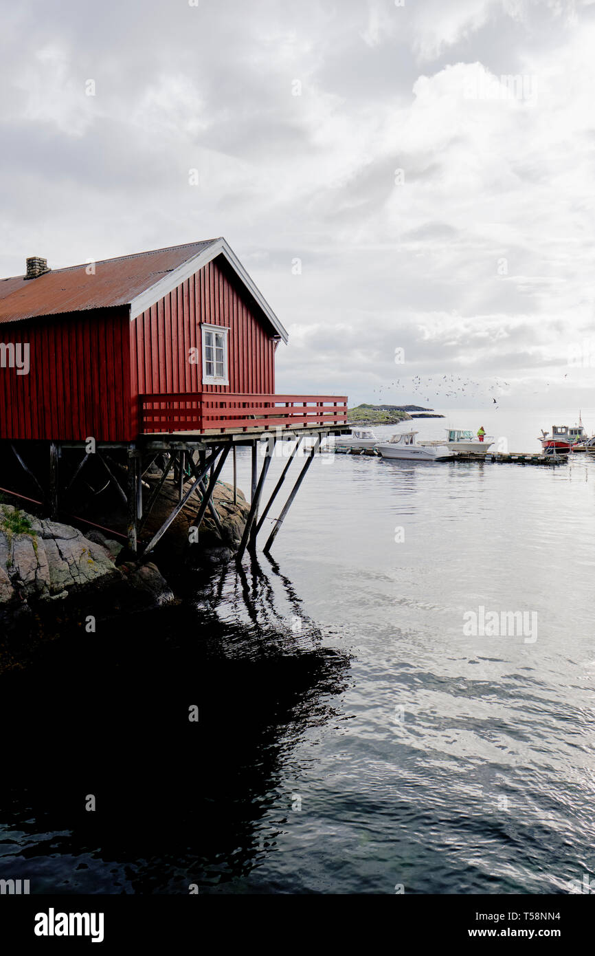 Un rosso Rorbu tradizionale norvegese casa di pescatori costruito su palafitte di legno nel villaggio di pescatori di Å su Moskenesøya nelle isole Lofoten in Norvegia Foto Stock