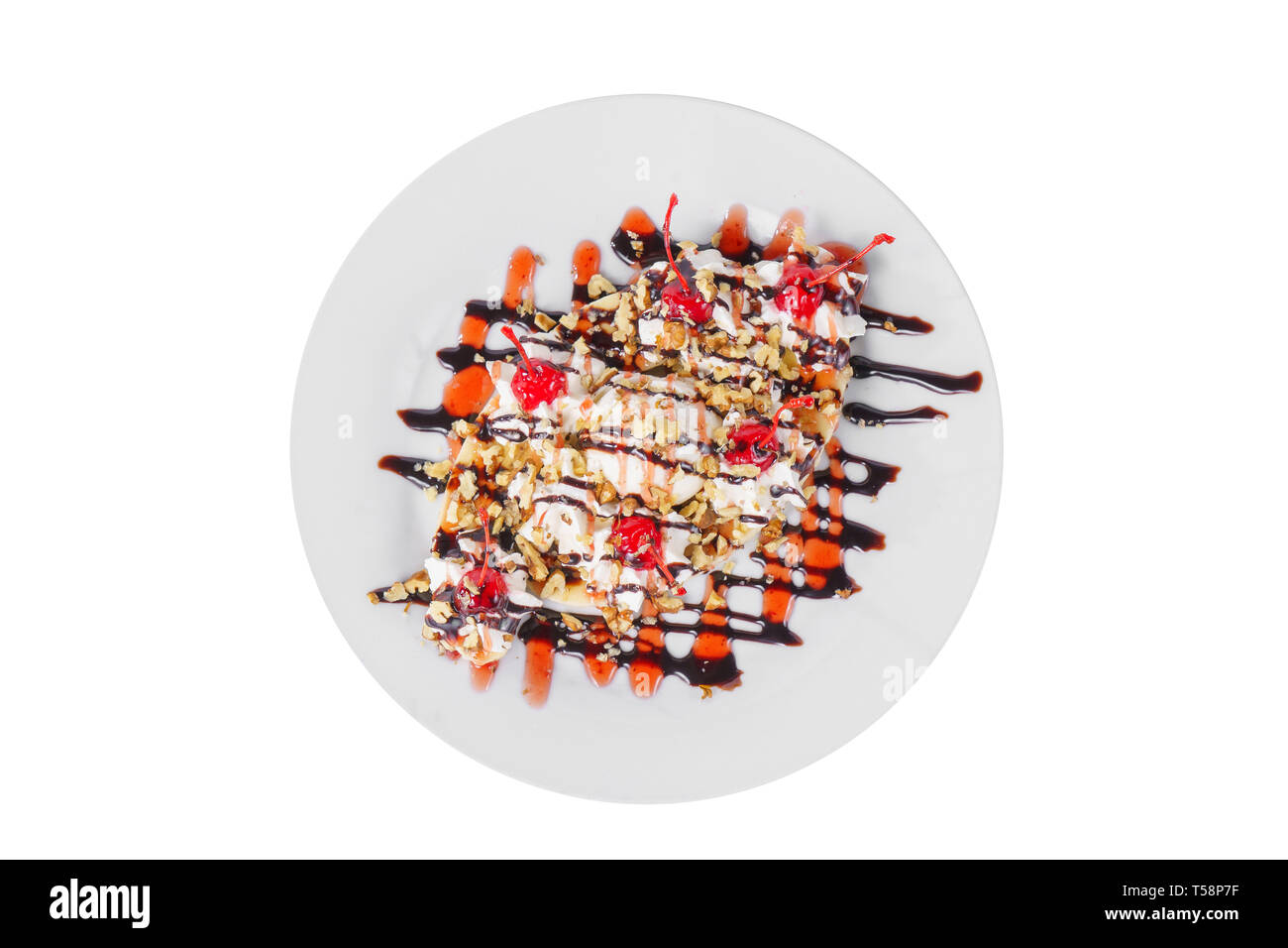 Il dessert di gelato vaniglia, panna montata, ciliegia, banana, cioccolato e berry topping, split, bianco sfondo isolato in vetro. Il piatto per il menu Foto Stock