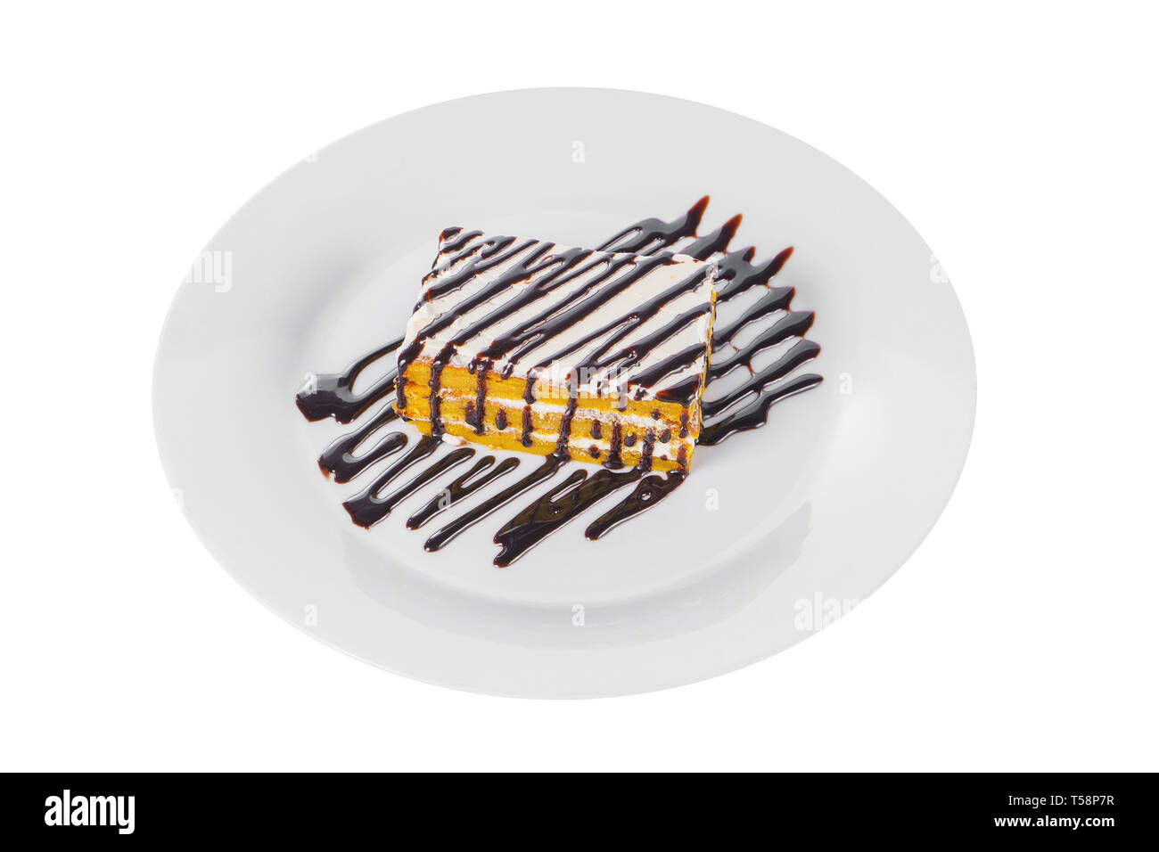 Biscotto di carota torta con crema e cioccolato topping, servita su una piastra isolata sfondo bianco. Dessert per un menu in una caffetteria, ristorante, caffè sho Foto Stock