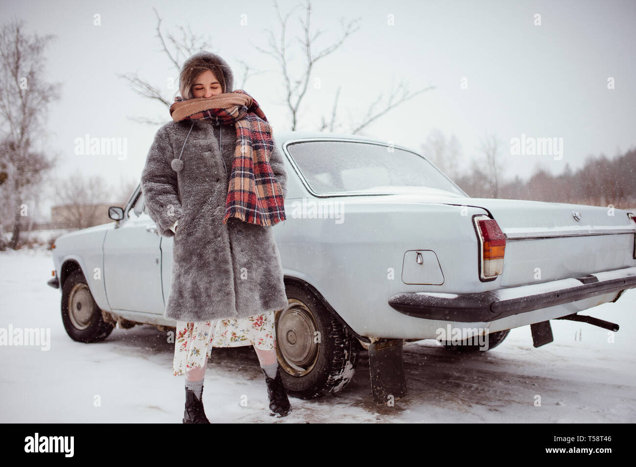 Inverno donna sorge nei pressi della macchina Foto Stock