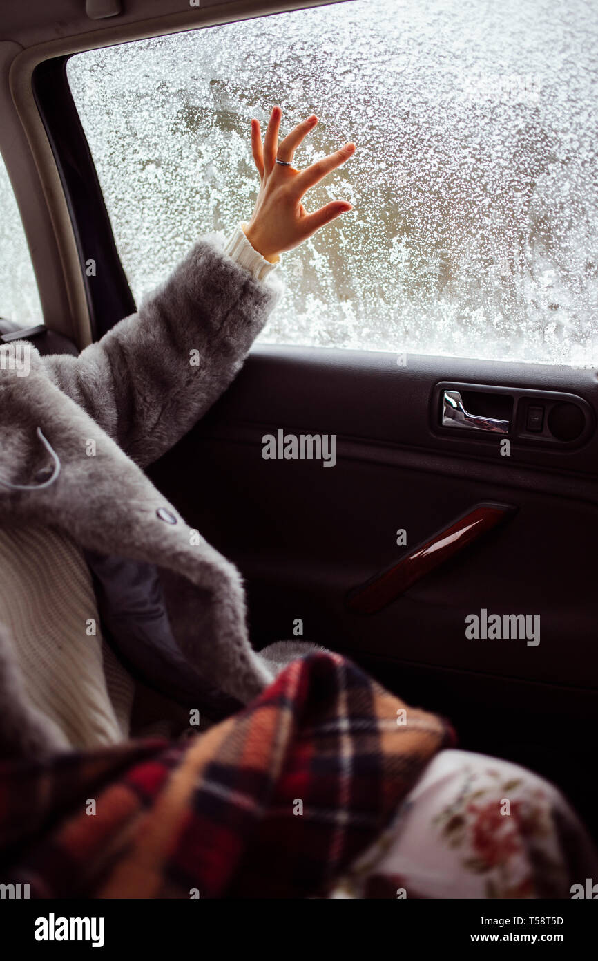 Femmina disegna a mano su una coperta di neve finestra. Foto Stock