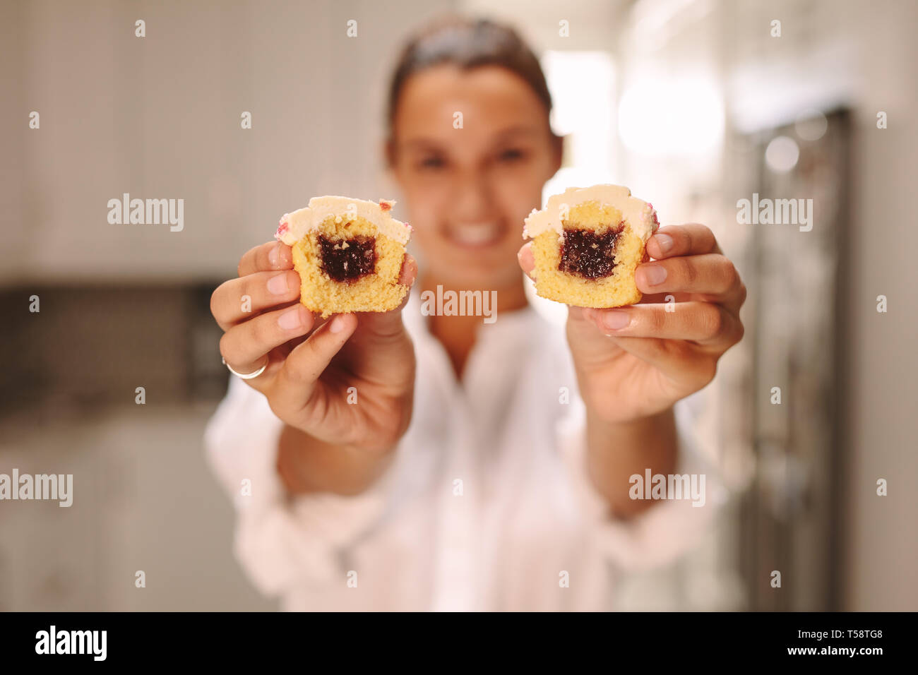 Pasticceria femmina mostra farcita tortina. Pastry chef mostra muffin fatti in casa. Foto Stock