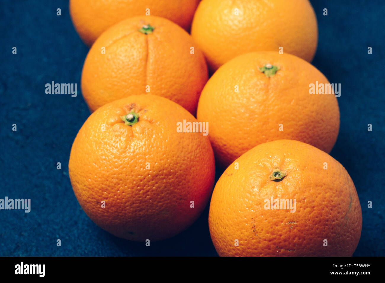 Ancora la vita di arance nella sua borsa su sfondo blu Foto Stock