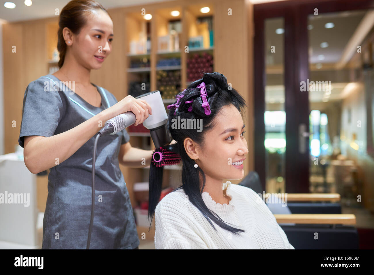 Salone di bellezza specialista per lo styling dei capelli del cliente Foto Stock