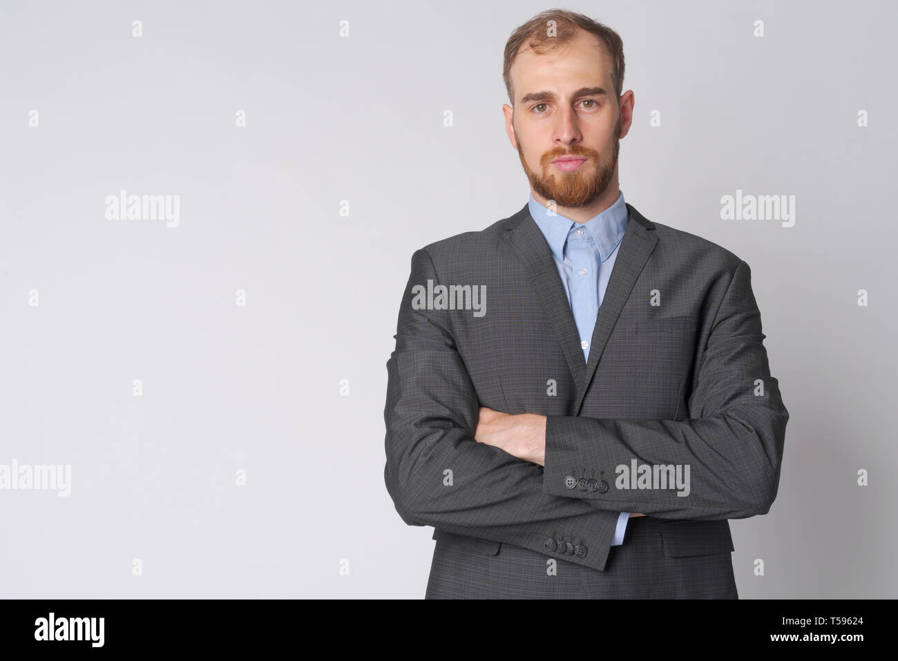 Ritratto di giovane imprenditore barbuto con le braccia incrociate Foto Stock