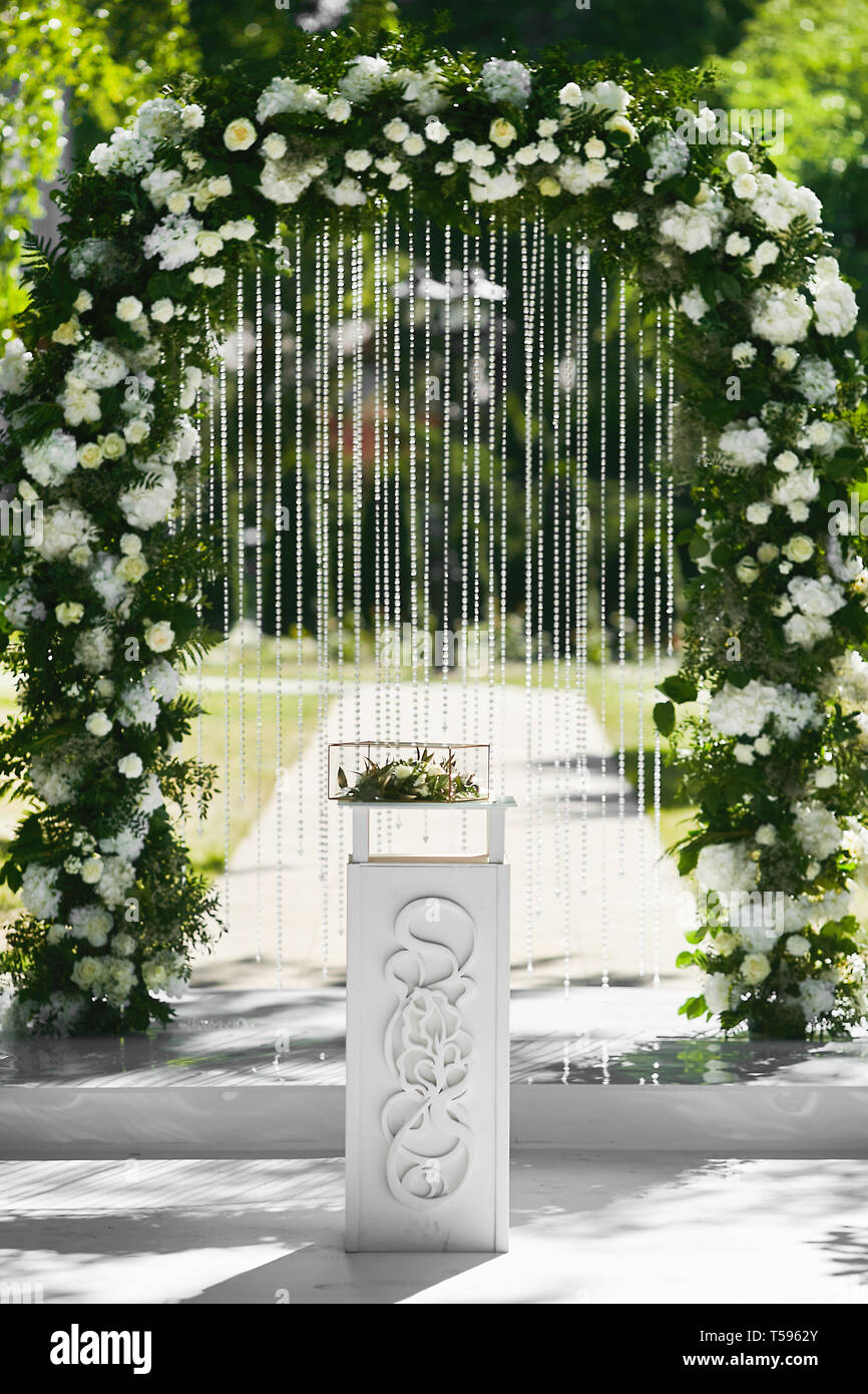 Nozze arrotondati arco floreale di fiori freschi all'aperto prima della  cerimonia di matrimonio - decorazioni per matrimoni Foto stock - Alamy
