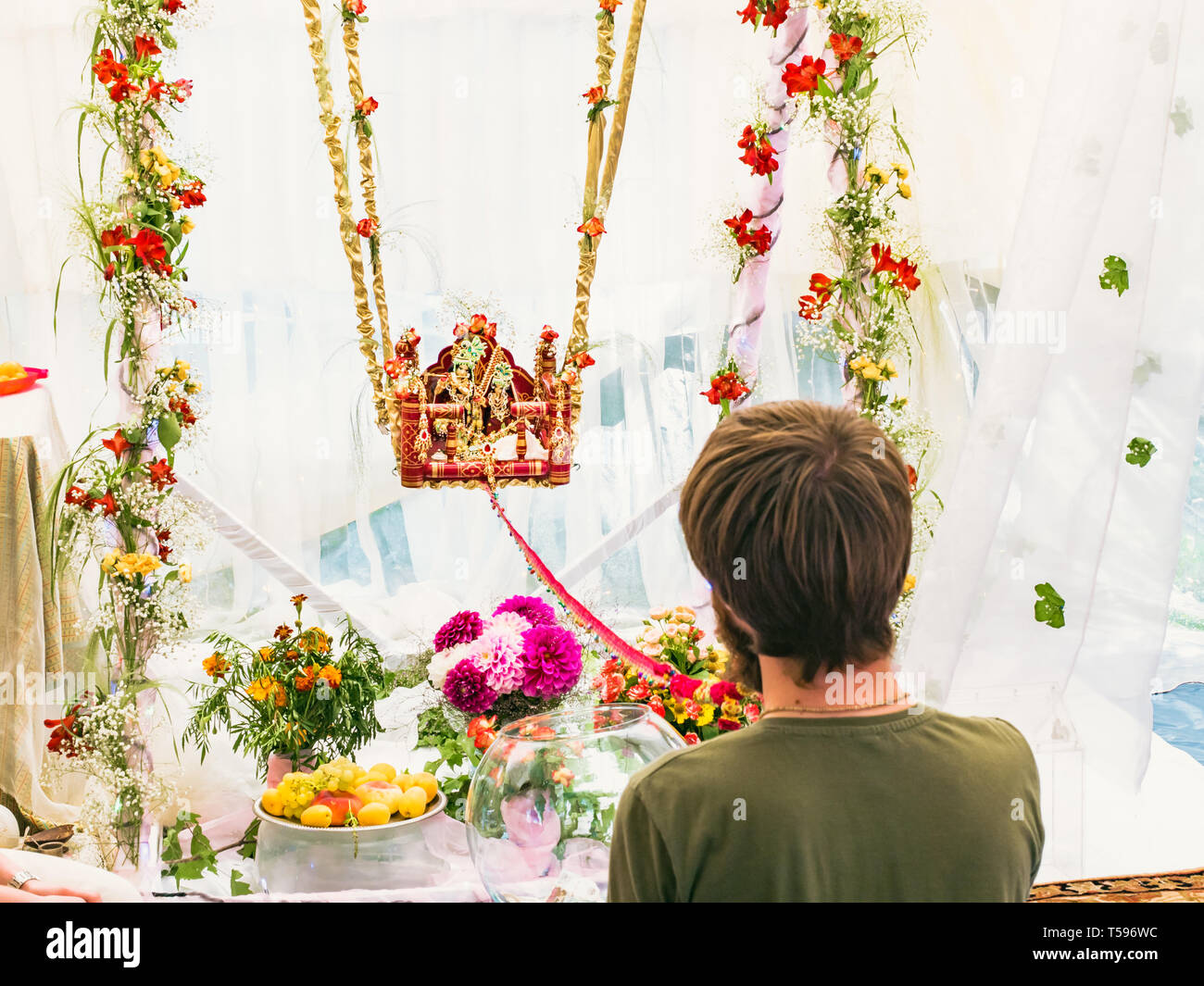 L'uomo far oscillare delicatamente su swing idoli di Radha e Krishna statua per mendicare la benedizione su Jhulan Yatra fest è il più grande e più popolare dei religiosi Foto Stock