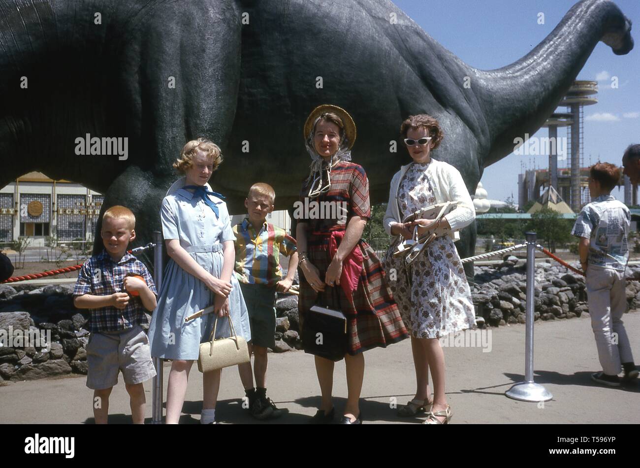 Una famiglia pone in una giornata di sole, di fronte a un Brontosaurus in fibra di vetro a Dinoland presentano, Sinclair Pavilion, 1964 alla fiera mondiale di New York, Flushing Meadows Park, Queens, a New York, maggio, 1964. () Foto Stock