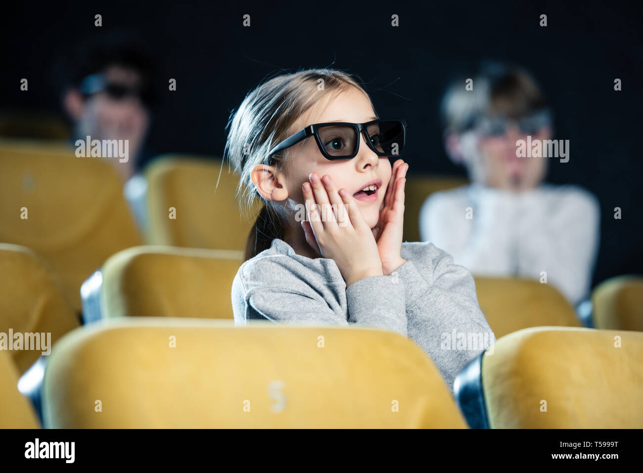 Messa a fuoco selettiva di preoccupato per il bambino di occhiali 3D tenendo le mani sul viso durante la visione di un filmato Foto Stock
