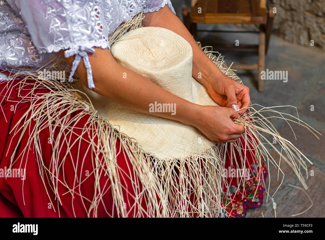 Donna tessitura di un cappello di Panama o colmato cappello di paglia da Toquilla fibre di palma. La tecnica è sulla lista del Patrimonio Culturale Immateriale elenco di Cuenca, Ecuador. Foto Stock