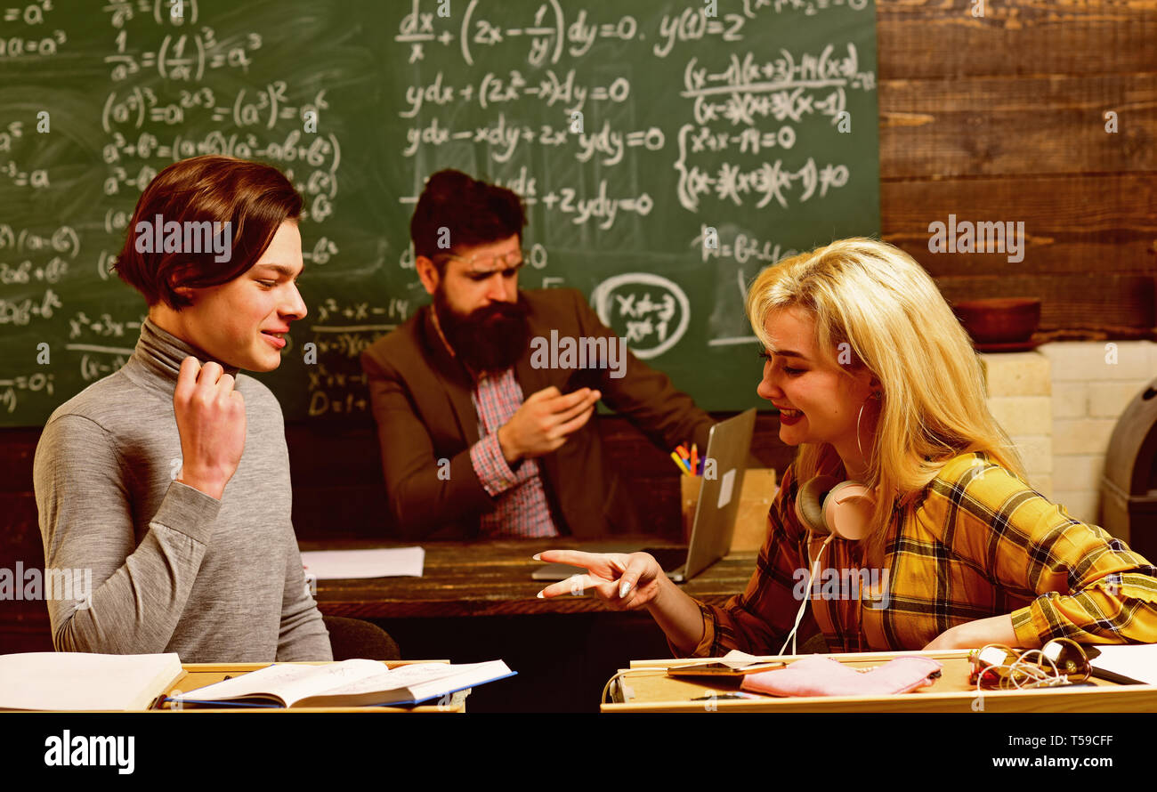 Conferenza degli studenti in soppalco interno spazio coworking utilizzando dispositivi digitali e wifi. Preparare gli studenti per gli esami in aula interno dietro la tabella. Foto Stock