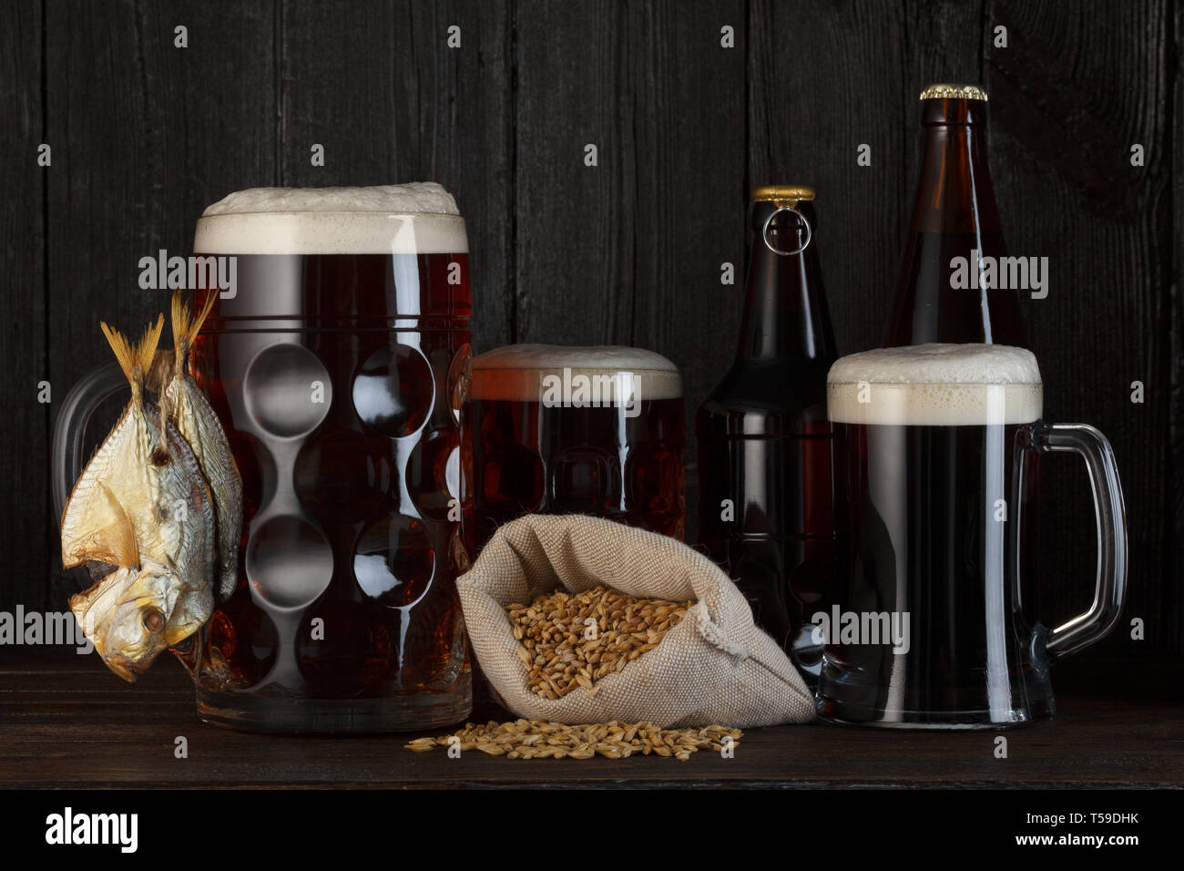 Boccali da birra e bottiglie con affumicato pesce salato snack e sacchetto di orzo Foto Stock