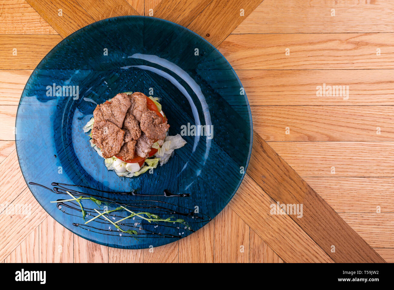 Il cibo italiano sfondo. Mozzarella, di foglie di basilico fresco, pomodoro, olio d'oliva, carne sulla piastra. Caprese salat ingredienti. Vista dall'alto. Foto Stock