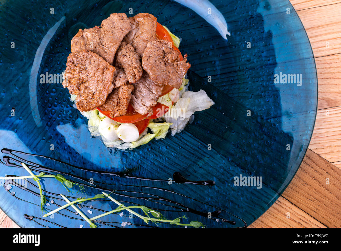 Il cibo italiano sfondo. Mozzarella, di foglie di basilico fresco, pomodoro, olio d'oliva, carne sulla piastra. Caprese salat ingredienti. Vista dall'alto. Foto Stock