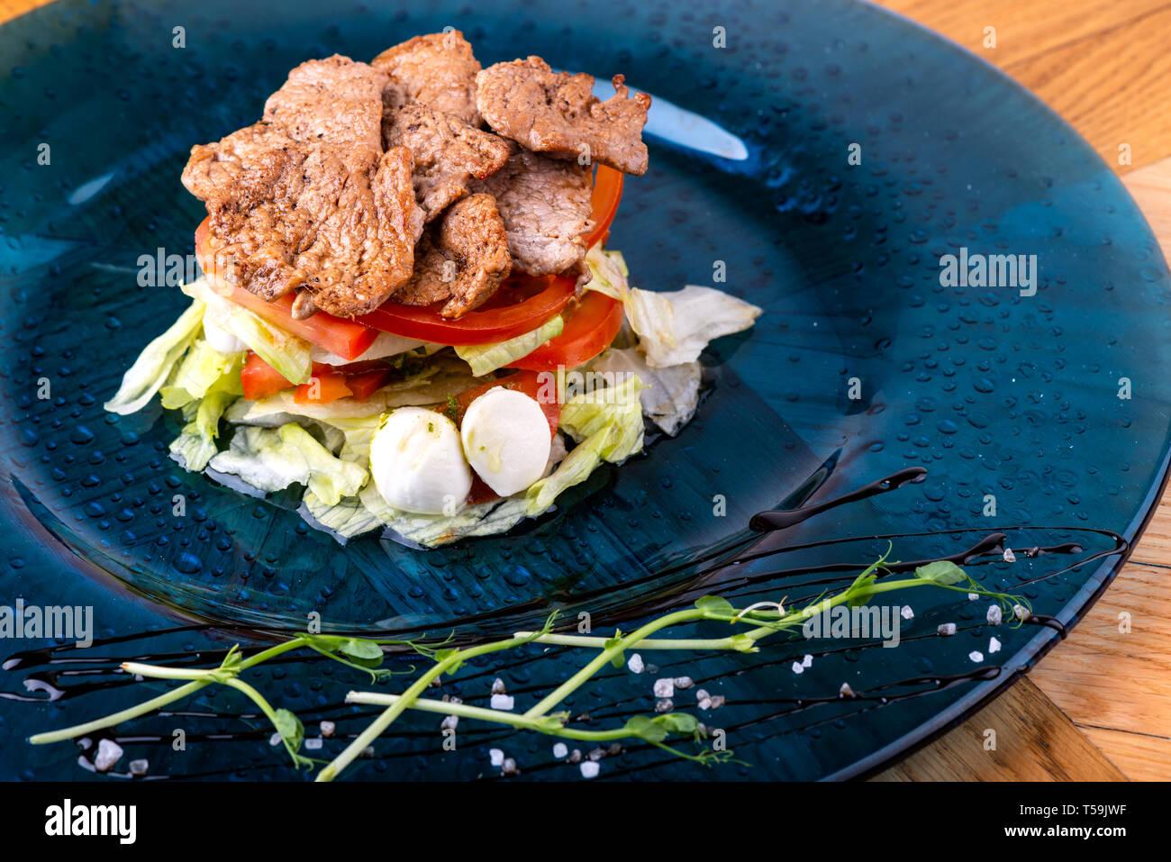Il cibo italiano sfondo. Mozzarella, di foglie di basilico fresco, pomodoro, olio d'oliva, carne sulla piastra. Caprese salat ingredienti. Close-up Foto Stock