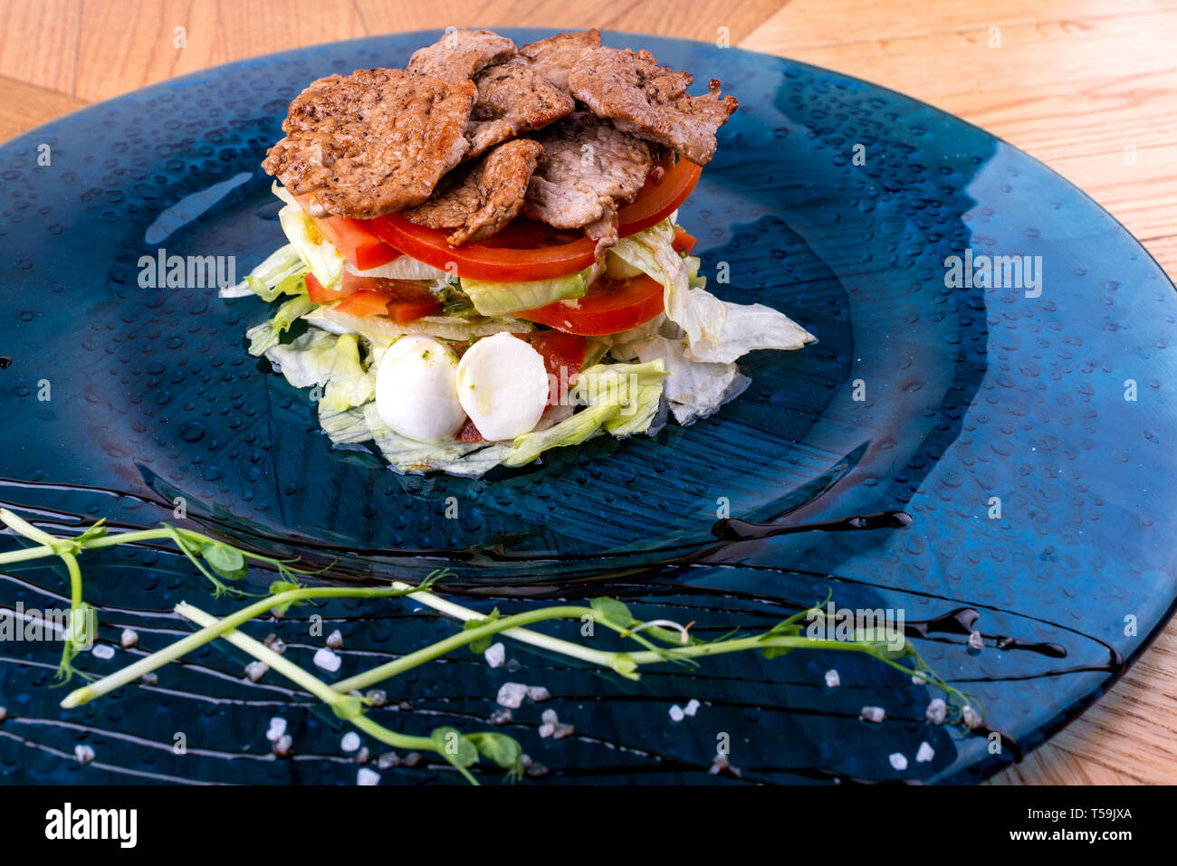 Il cibo italiano sfondo. Mozzarella, di foglie di basilico fresco, pomodoro, olio d'oliva, carne sulla piastra. Caprese salat ingredienti. Close-up Foto Stock