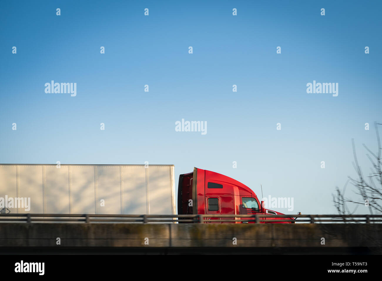 Semi carrello su autostrada al tramonto trattore rosso con il blu del cielo Foto Stock